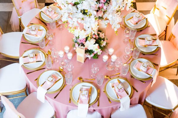 Beautiful dinner table decorated by gold accessories and flowers